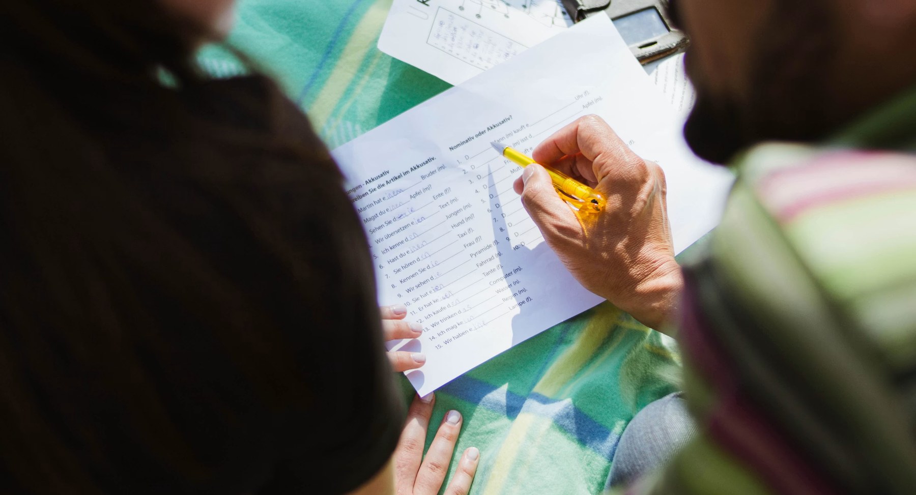 An adult and a child going over written work together