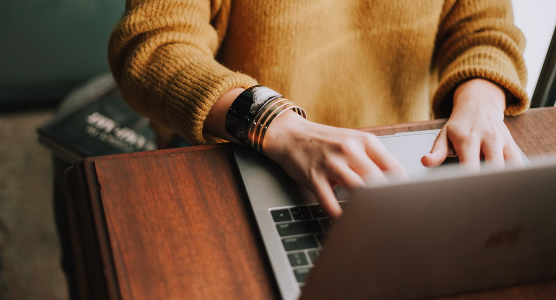 A person working on a laptop at a table at home